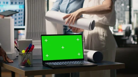 Real estate experts analyzing blueprints and models next to green screen Stock Footage 316642295