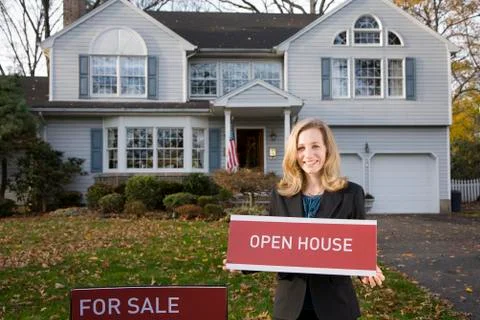 A real estate t holding an OPEN HOUSE sign Stock Photos