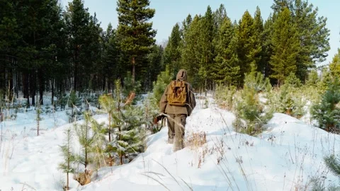 A real hunter with a gun in the winter forest. Winter hunting. Stock Footage 326924422