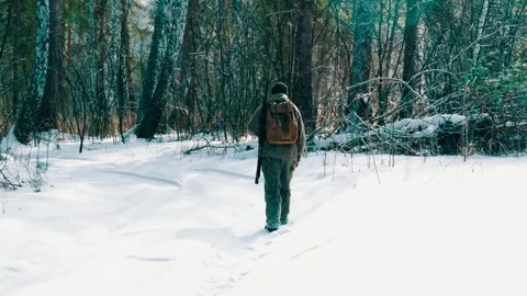 A real hunter with a gun in the winter forest. Winter hunting. Stock Footage 326925882