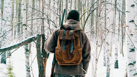 A real hunter with a gun in the winter forest. Winter hunting. Stock Footage 326926733