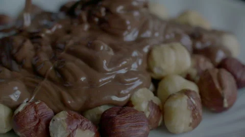 Real Liquid Chocolate Covers Hazelnuts in slow motion scene Stock Footage