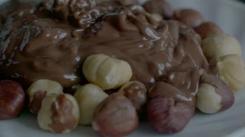 Real Liquid Chocolate Covers Hazelnuts in slow motion scene Stock Footage