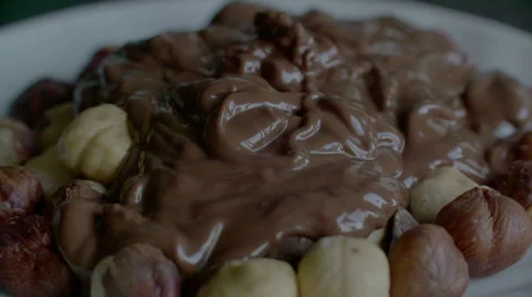 Real Liquid Chocolate Covers Hazelnuts in slow motion scene Stock Footage