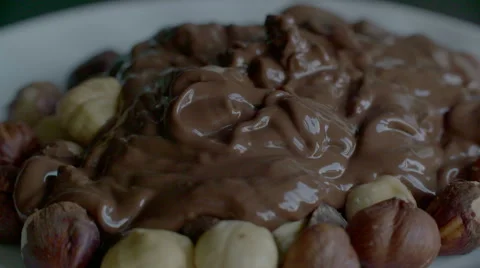 Real Liquid Chocolate Covers Hazelnuts in slow motion scene Stock Footage