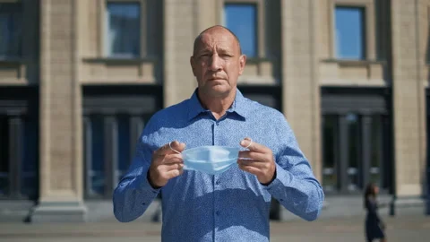 Real old age man put mask, protecting dangerous influenza and germs. Covid-19. Stock Footage 137534318