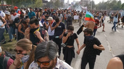 Real people crowd protesting and repealed with tear gas at Santiago de Chile Vídeos de archivo 119260994