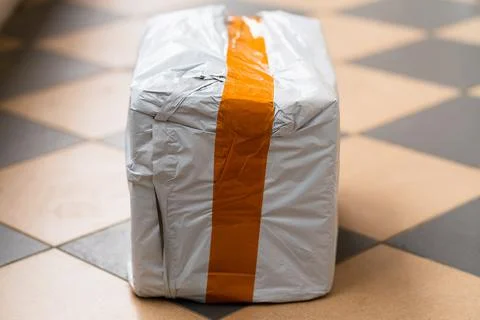 Real postal package, white box with orange stripe with ordered item Stock Photos