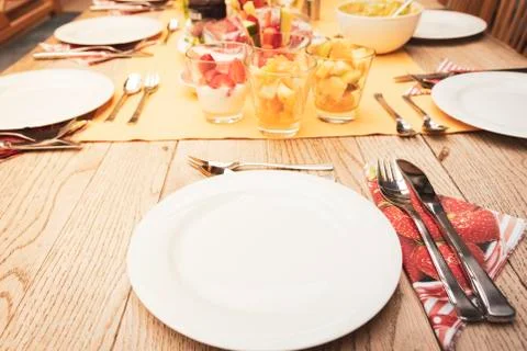 Real set breakfast table with small glass bowls full of fruits and fish, yellow Stock Photos