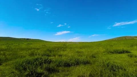 Real Shot of Boundless Flat Green Grassland Long Country Road Clear Sky in Inner Video stock 337980717
