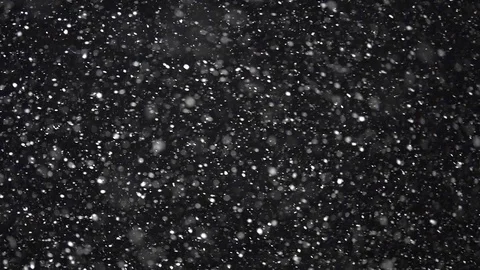 Real snow falling at night backlit with out-of-frame light in slow motion. Stock Footage 108014713