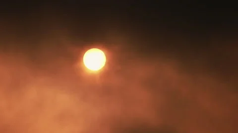 Real time aerial setting sun hides/emerges behind clouds and heavy fog Stock Footage 48560916