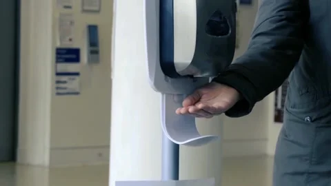 Real time, close shot of hands taking gel sanitizer from dispenser Stock Footage 131543770