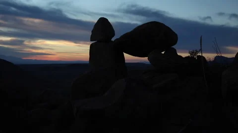 Real Time of dawn clouds in blue sky silhouetting Balanced Rock in Big Bend Stock Footage 166812964