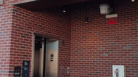 Real time elevator opening and closing on brick concourse wall Stock-Footage 332630099