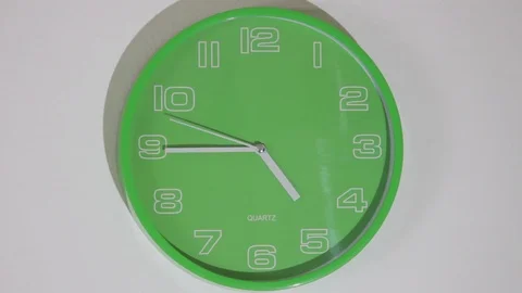 Real time green clock hanging on the wall Vídeos de archivo 116899856