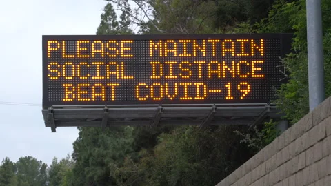 Real time long shot of a COVID-19 social distance highway sign in Los Angeles Video stock 130930849