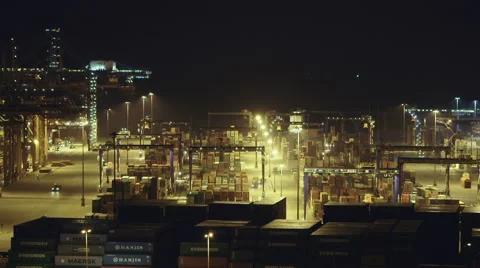 Real time ,night ,establishing shot trading port activity cranes trucks Stock Footage 48618280