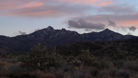 Real Time of pink sunset clouds in blue sky and snowy Hualapai Mountains Stock Footage 167856306