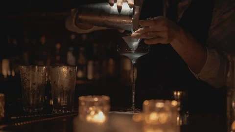 Real time shot of a bartender pouring a cocktail into a glass. Bartender Video stock 129493210
