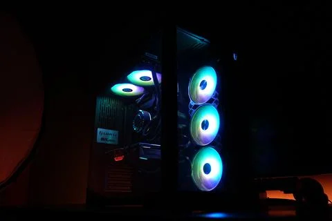 A real time shot of A black CPU casing with rgb fans in a dark room Stock Photos