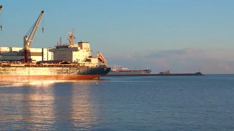 Real time shot of large freighters docked at the port on sunny day. Stock Footage 136587118
