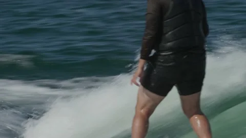 Real time shot of Man wake surfing behind boat in Lake Travis in Texas in summer Stock Footage 234033324