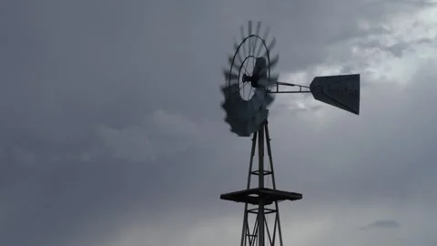 Real time of a spinning, rotating windmill and rain clouds in west Texas Stock Footage 166875757