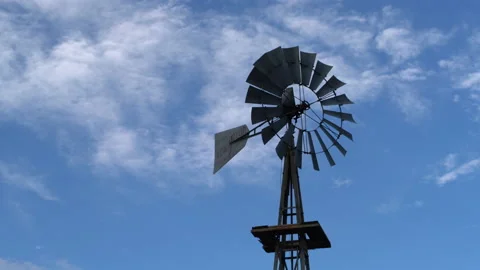 Real time of a stationary windmill and wispy clouds in blue sky in west Texas Stock Footage 166876012