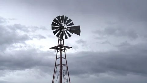 Real Time of a still old windmill and dark rain clouds in the American west Stock Footage 170676412