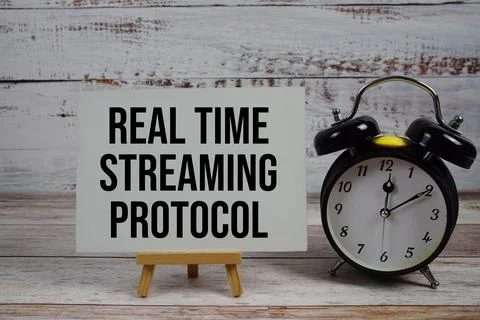 Real Time Streaming Protocol text with easel and alarm clock on wooden back.. Foto stock