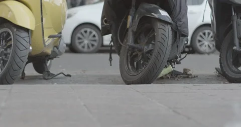 Real time street level pan of sidewalk showing feet of pedestrians, scooter Stock Footage 169717565