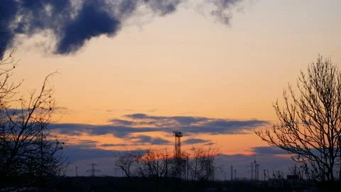 Real time sunrise. Trees, power poles, wind turbines. Sky, clouds, smoke, birds. Stock Footage 152157971