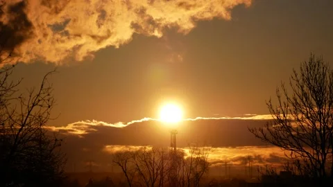 Real time sunrise. Trees, power poles, wind turbines. Sun flash. Sky, clouds. Stock Footage 152159700