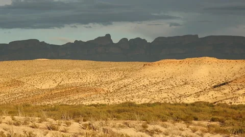 Real Time of sunset light casting dark cloud shadows on the Sierra del Carmen Stock Footage 166813028
