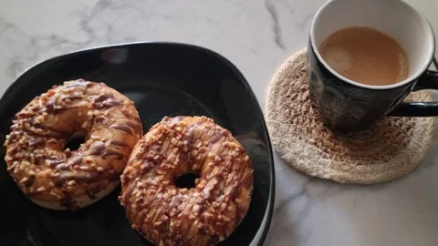Real Time Video of Salted Caramel Donuts and Coffee Mug on Cafe Table Stock Footage 346522187