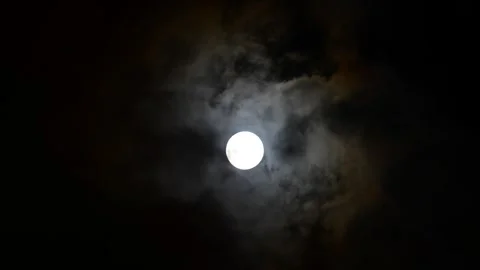 Real time video of thin clouds passing in front of the full moon Stock Footage 328494358