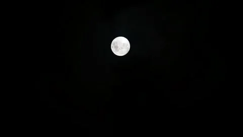 Real time video of thin clouds passing in front of the full moon Stock Footage 328494360