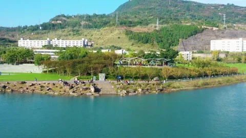 Real Time View of People Sunbathing in Riverside Park Urban Lifestyle Stock Footage 319639347
