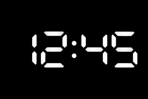 Real white led digital clock on black background Stock Photos