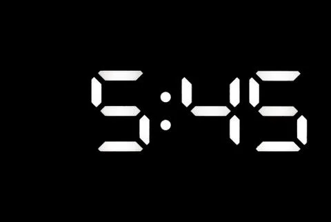 Real white led digital clock on black background Stock Photos