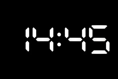 Real white led digital clock on black background Stock Photos