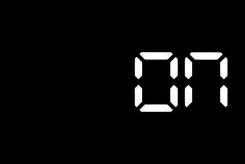Real white led digital clock on black background Stock Photos