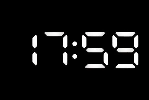 Real white led digital clock on black background Stock Photos