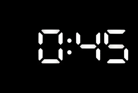 Real white led digital clock on black background Stock Photos