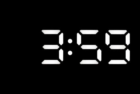 Real white led digital clock on black background Stock Photos