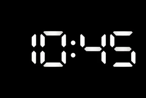 Real white led digital clock on black background Stock Photos