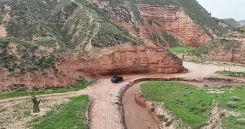 Real-world video: Aerial View Of Danxia Canyon With SUV And Dinosaur Sculpture Vídeos de archivo 312919242