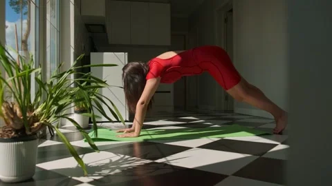 Realistic first yoga practice at home, woman stretching near kitchen in morning Video stock 309662416