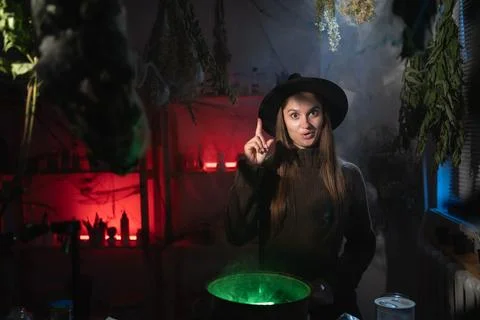 Realistic witch brewing a potion in cauldron showing great idea gesture has.. Stock Photos